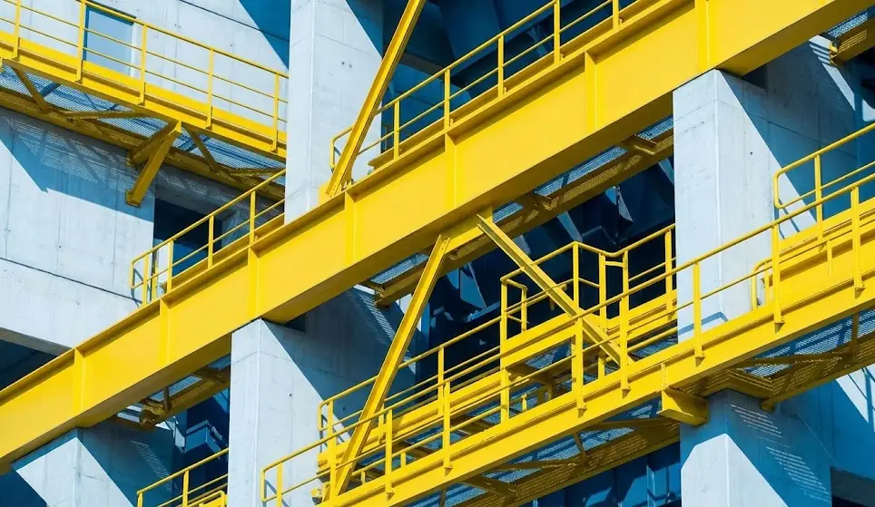 Yellow steel walkways and beams on a concrete industrial structure